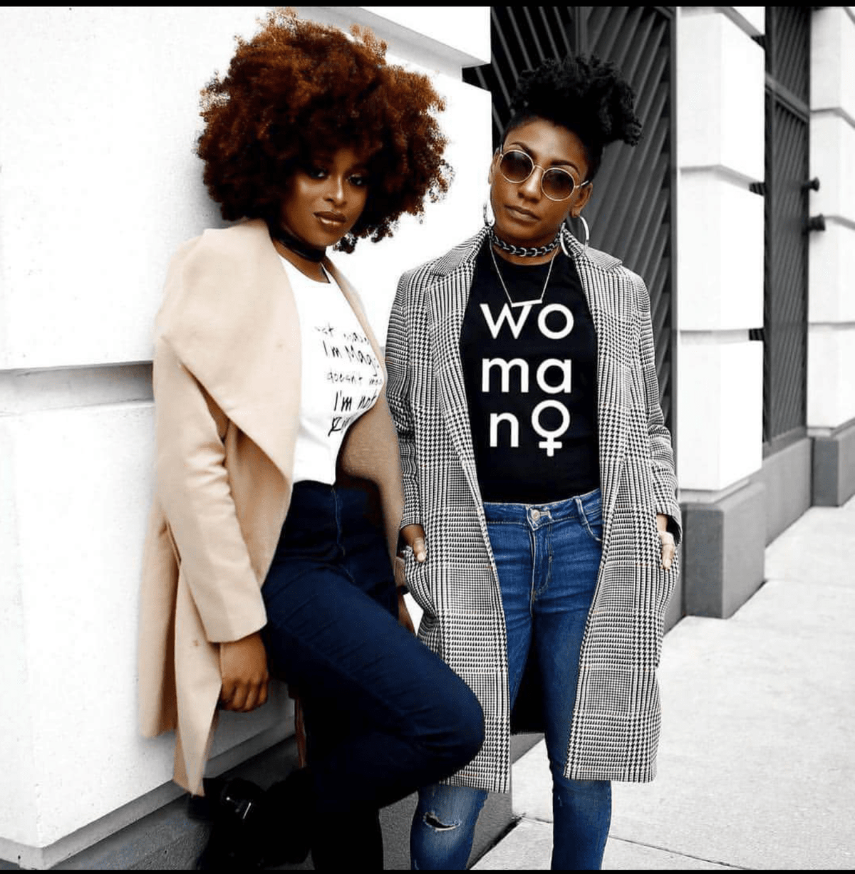 Two black women wearing jeans, jackets, and graphic tees