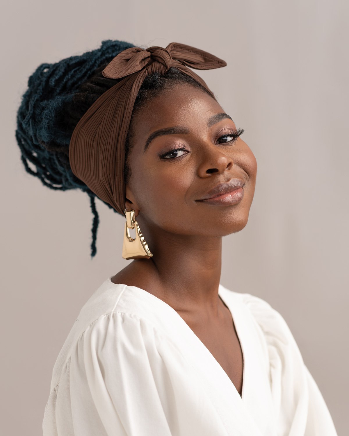 Black woman smiling in a brown head wrap