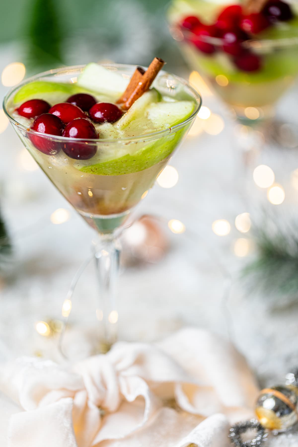 Apple White Grape Mocktail in a martini glass on a table set with Christmas decorations