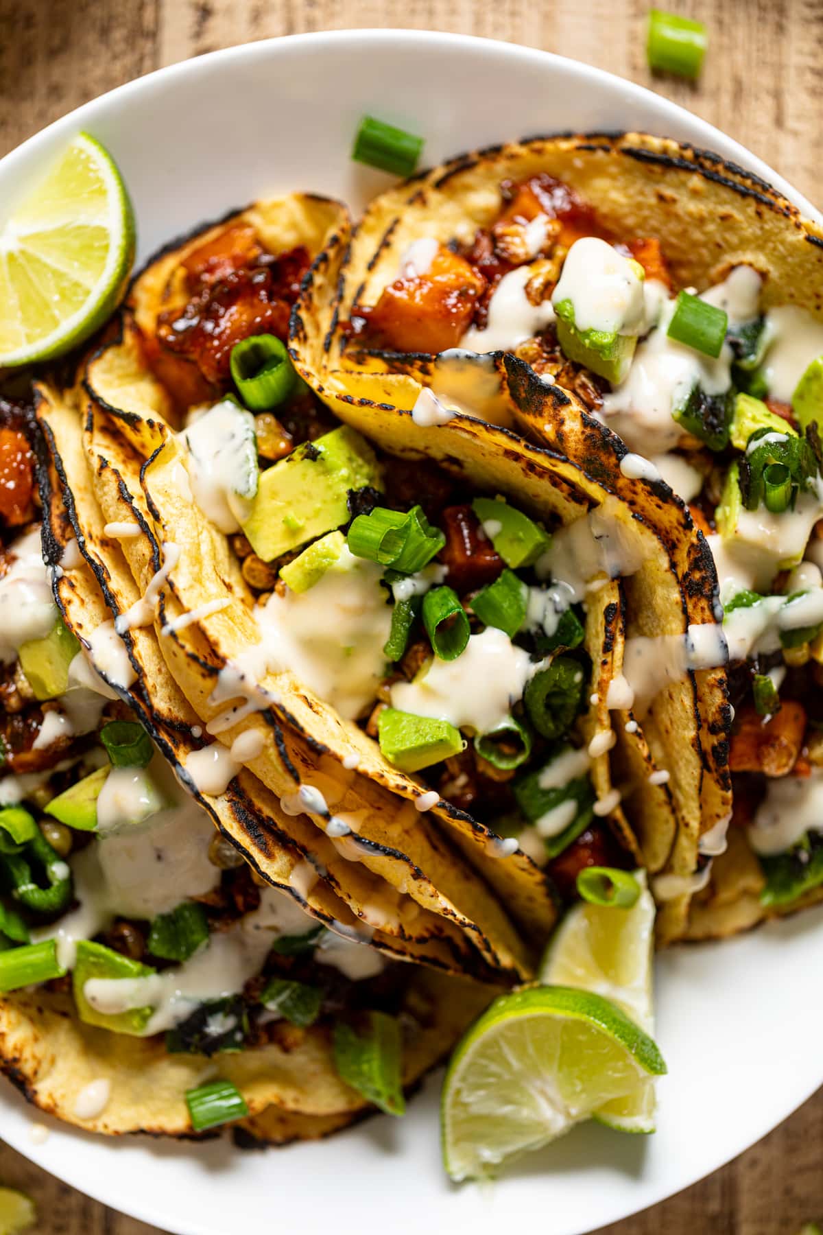 Closeup of Chipotle BBQ Butternut Squash Tacos drizzled with dairy-free garlic lime sauce