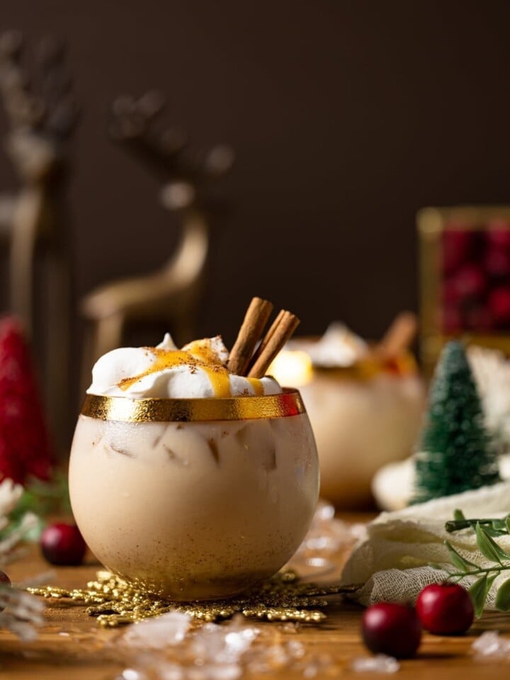 Vegan Caramel Eggnog Mocktail on a table full of Christmas decorations