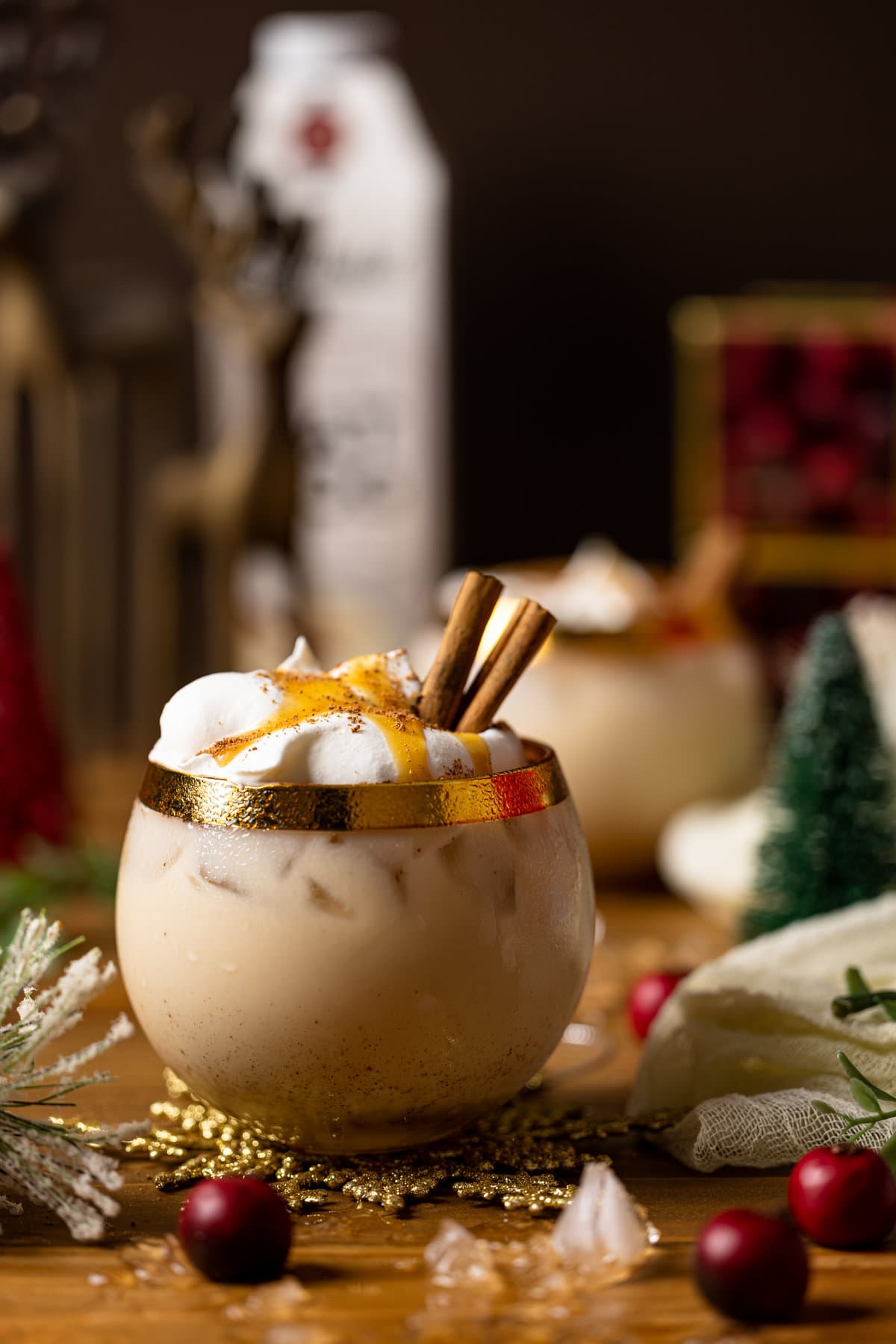 Vegan Caramel Eggnog Mocktail on a table full of Christmas decorations
