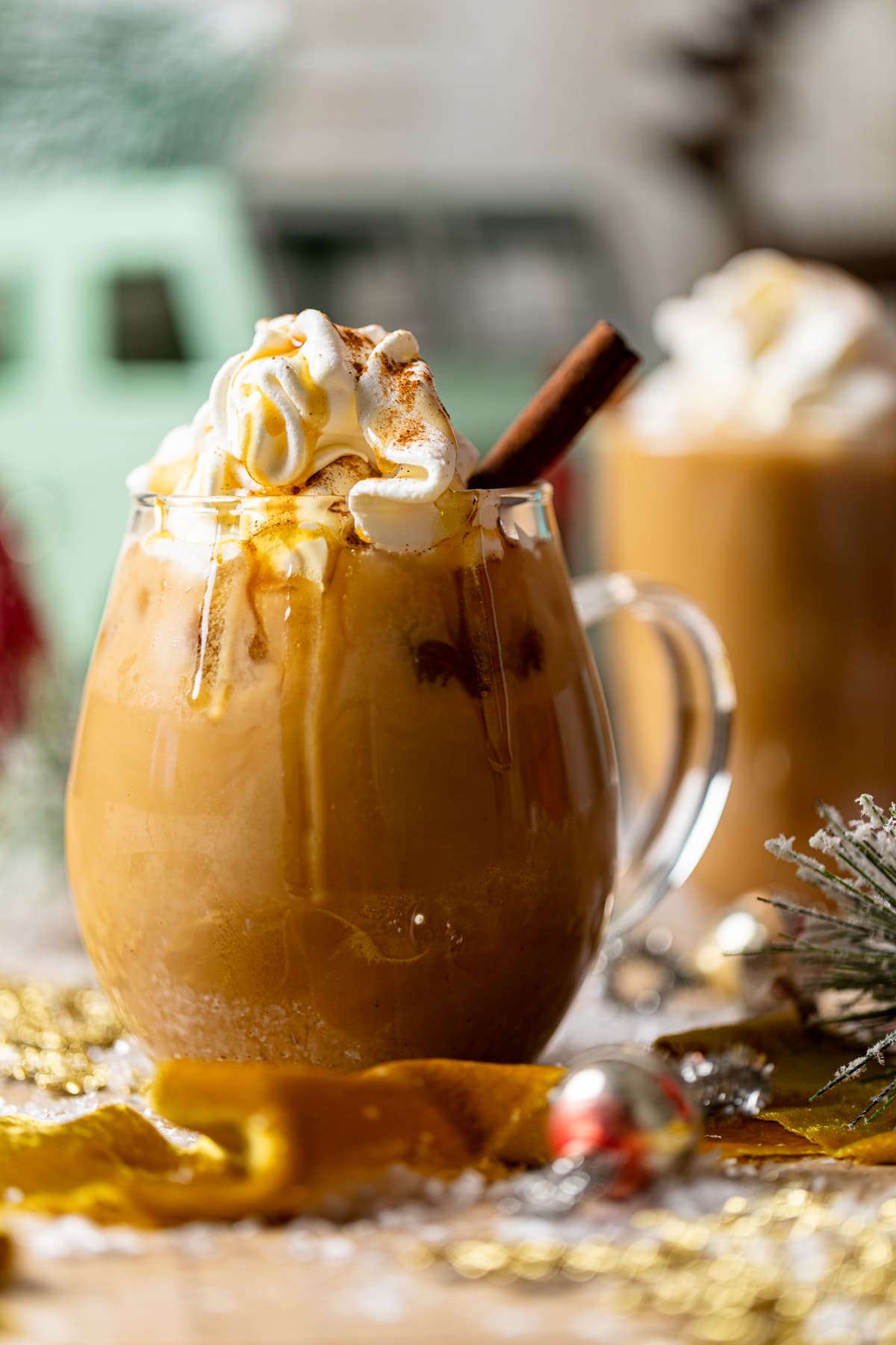 Iced Maple Cinnamon Oat Latte in a glass mug with maple syrup drizzling over the side