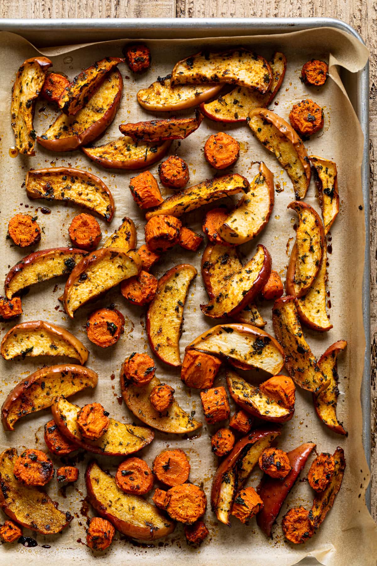 Sheet pan of seasoned and roasted apple and carrot slices