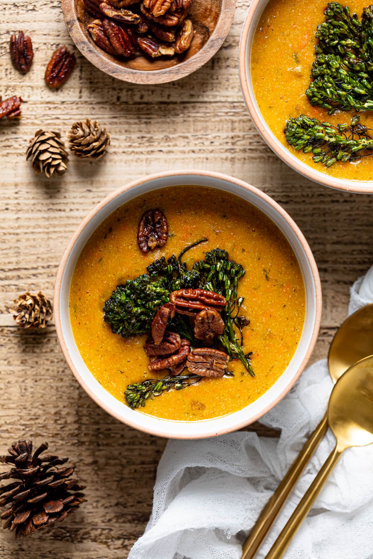Overhead shot of two bowls of plant-based Cheddar Carrot Apple Soup