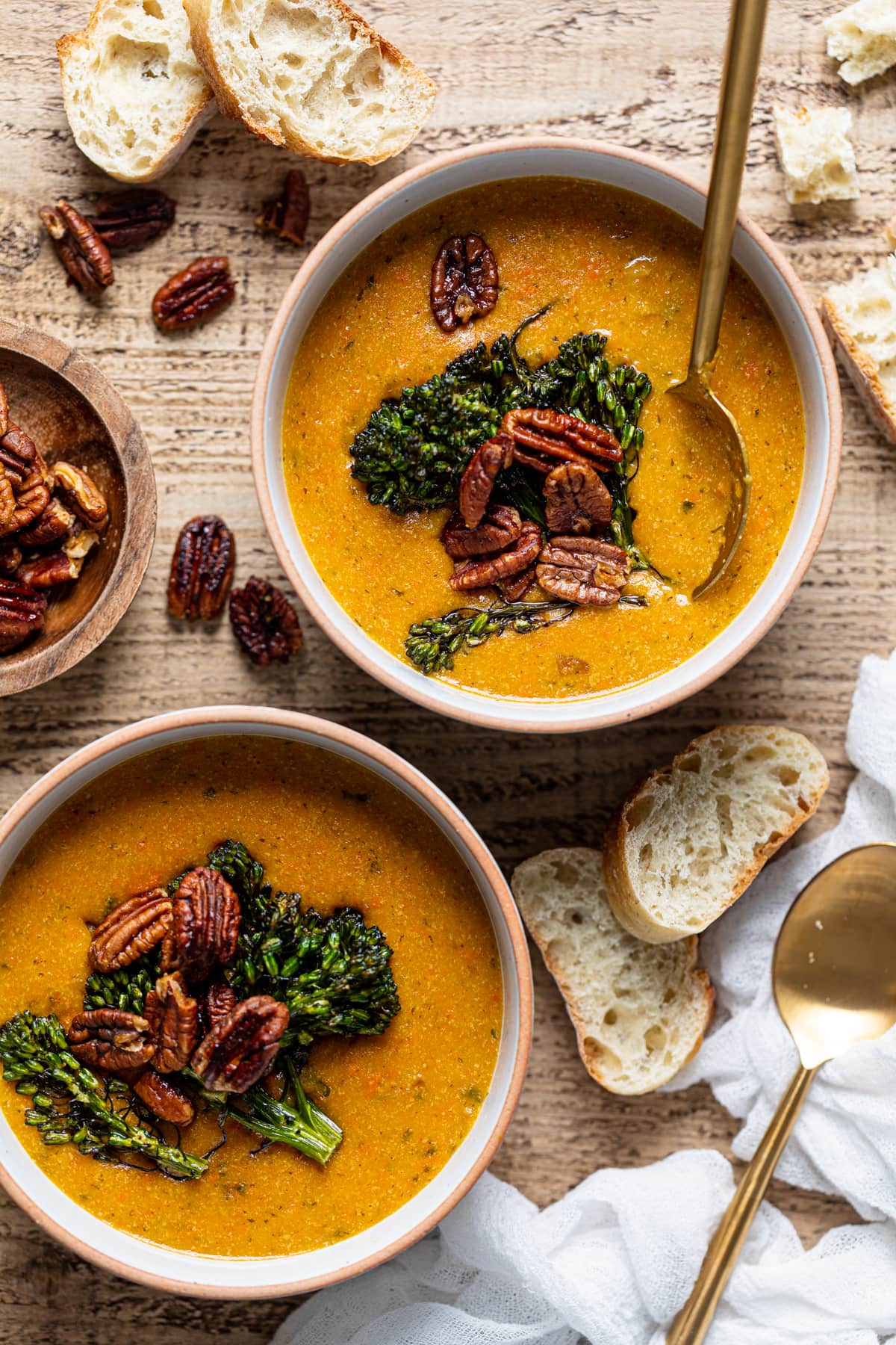 Overhead shot of two bowls of plant-based Cheddar Carrot Apple Soup