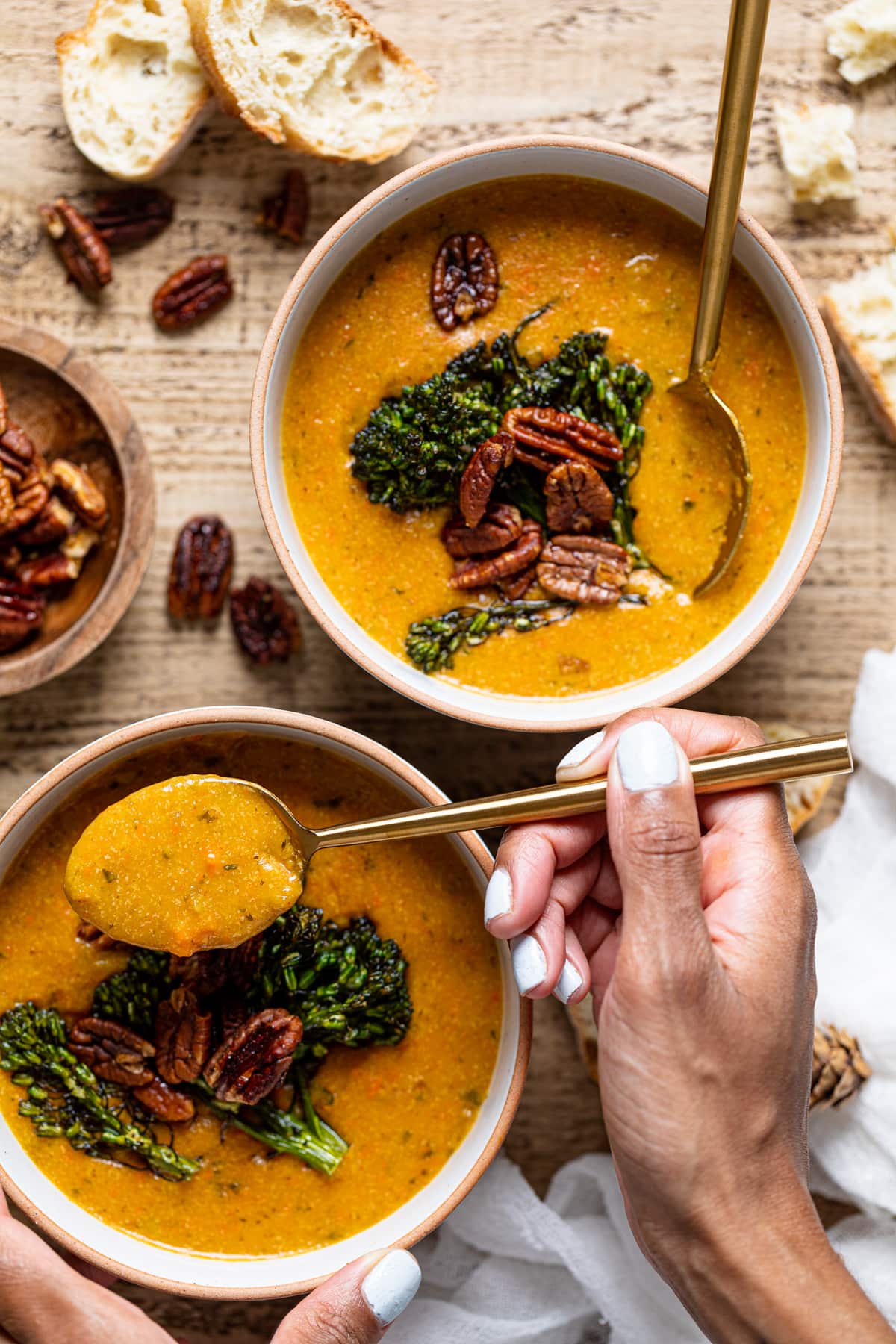 Overhead shot of two bowls of plant-based Cheddar Carrot Apple Soup with spoons