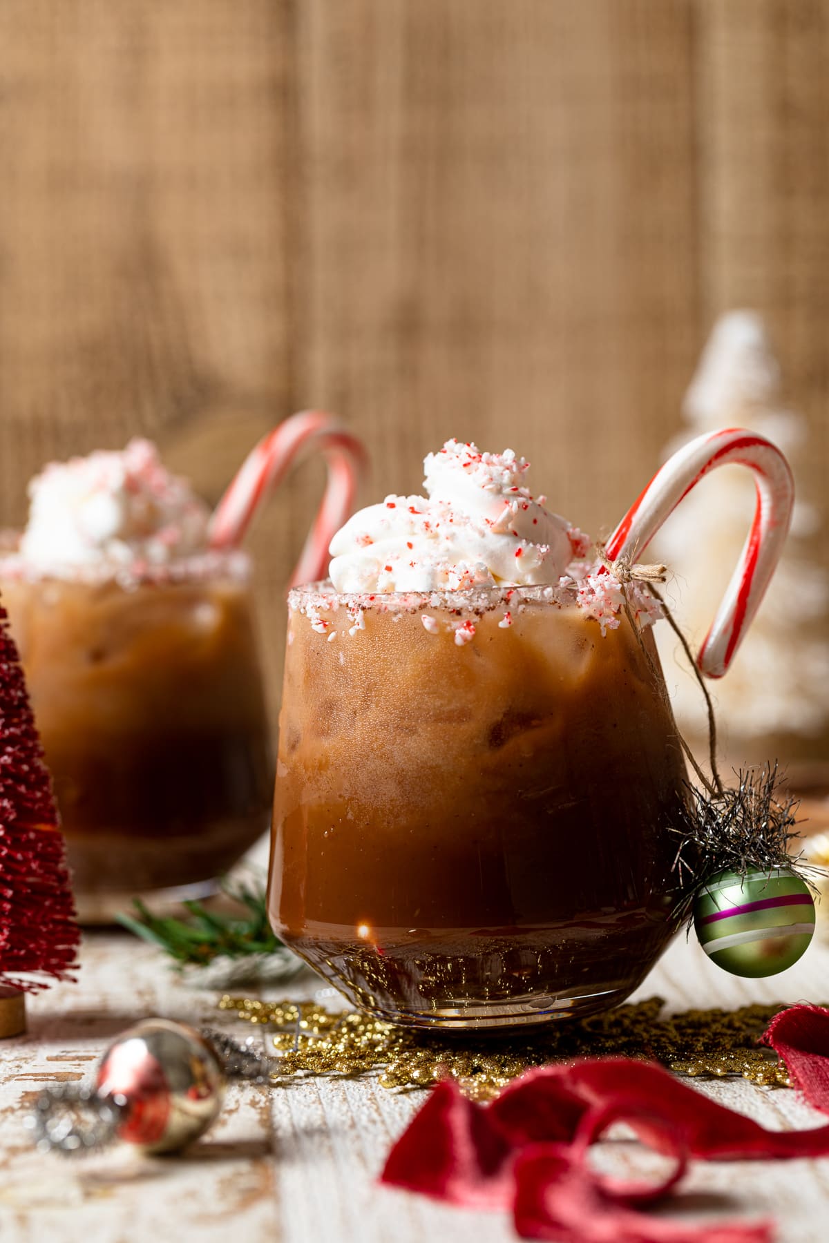 Two small glasses of Chocolate Christmas drinks with candy canes 