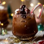 Chocolate syrup pouring onto a Chocolate Christmas Mocktail with a candy cane