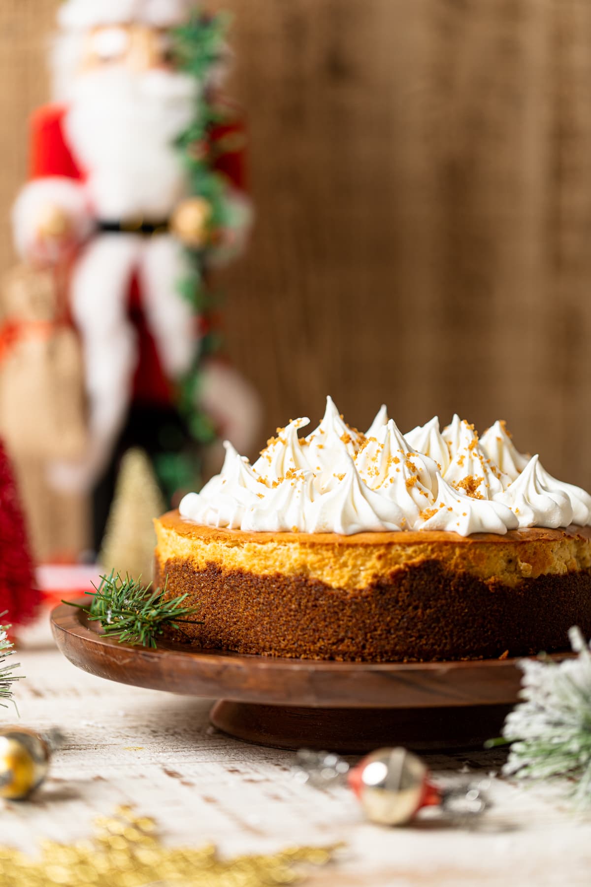 Eggnog Cheesecake with Snickerdoodle Crust on a wooden serving platform