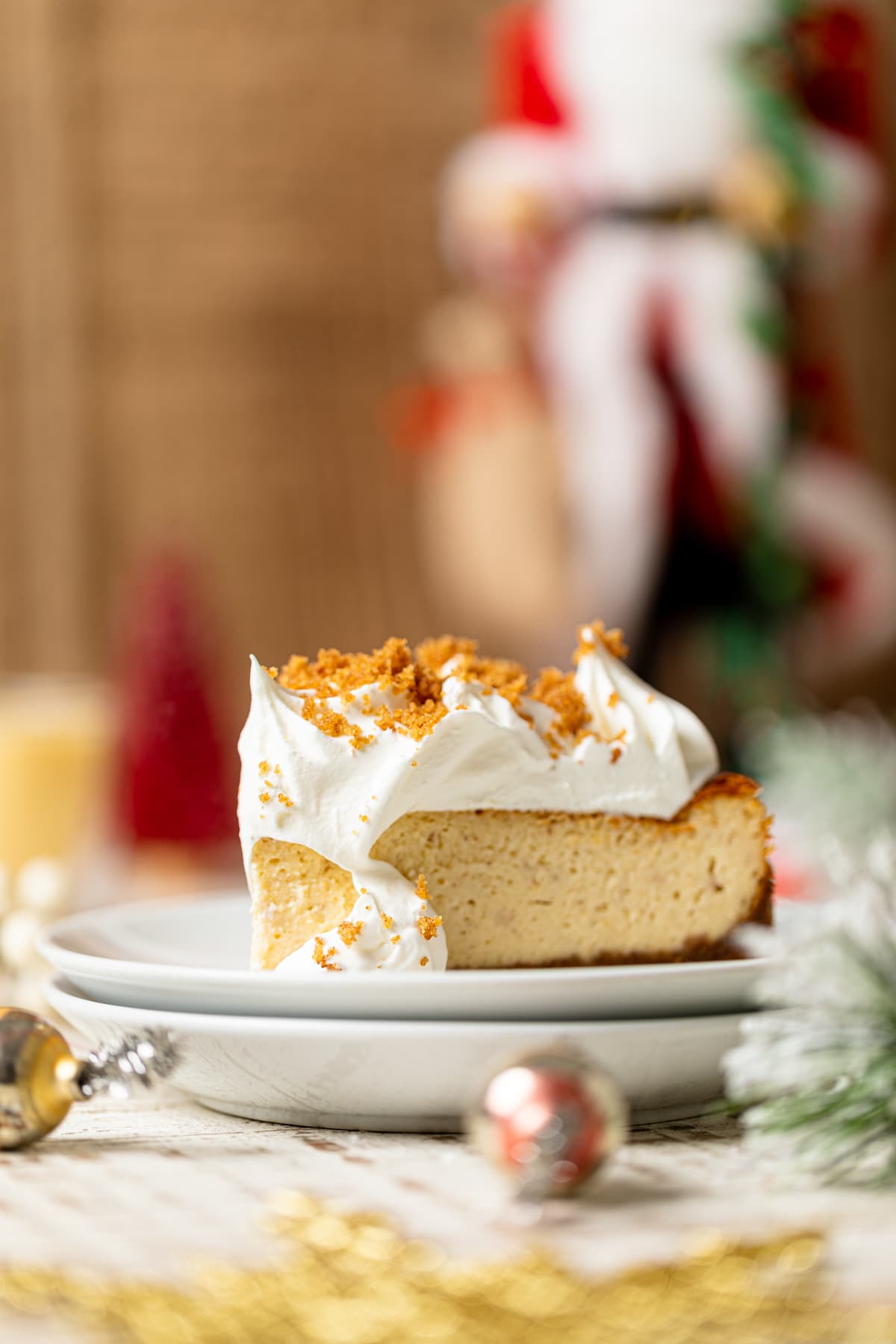 Slice of Eggnog Cheesecake with Snickerdoodle Crust on two small, stacked plates