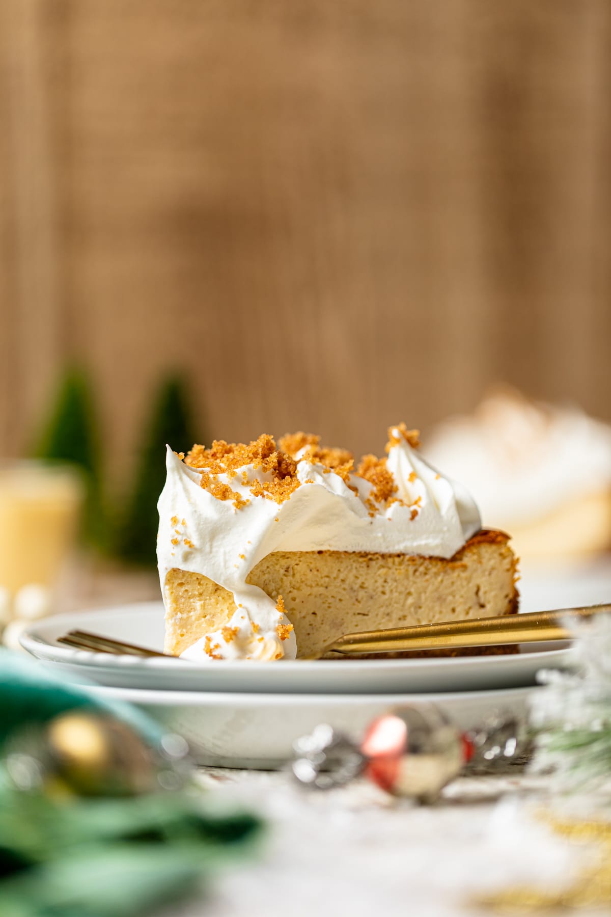 Side view of a slice of Cheesecake with Snickerdoodle Crust on two small, stack plates with a fork