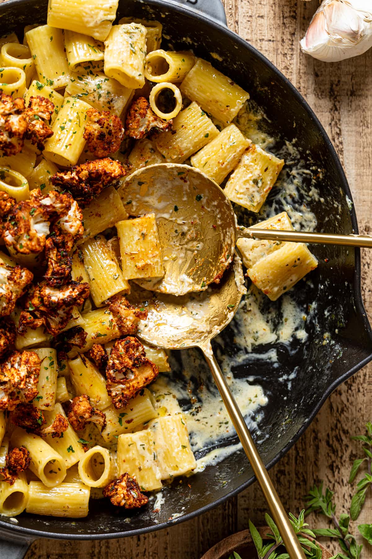 Two spoons in a skillet of Creamy Garlic Butter Pasta with Roasted cauliflower