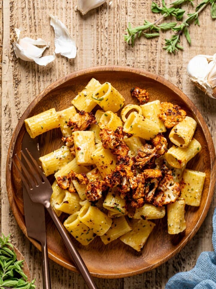 Creamy Garlic Butter Pasta with Roasted cauliflower on a wooden plate