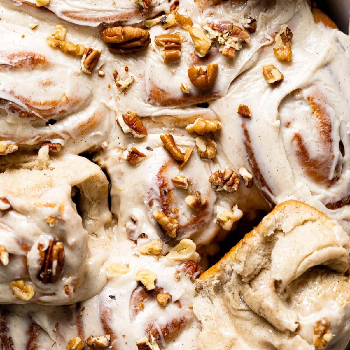 Up close of frosted rolls with a garnish of chopped nuts.