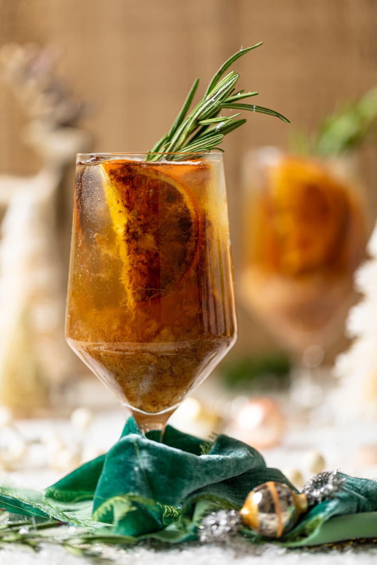 Closeup of a Spiced Maple Citrus Pear Mocktail in a glass wrapped with a green cloth