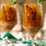 Two Spiced Maple Citrus Pear Mocktails on a table with Christmas decorations