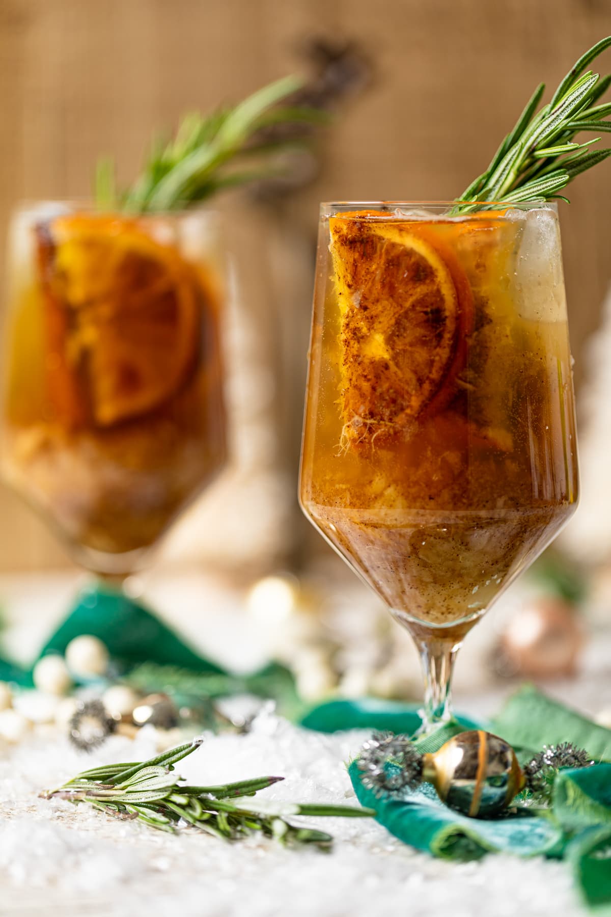 Two Spiced Maple Citrus Pear Mocktails on a table with Christmas decorations