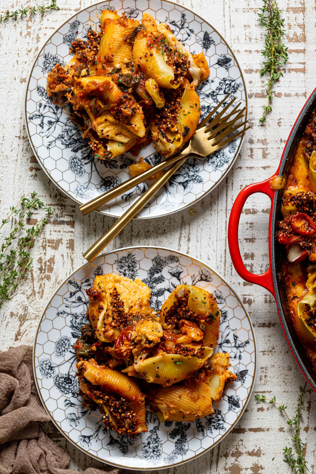 Overhead shot of a pan and two plates of Butternut Squash Stuffed Shells with Quinoa and Kale