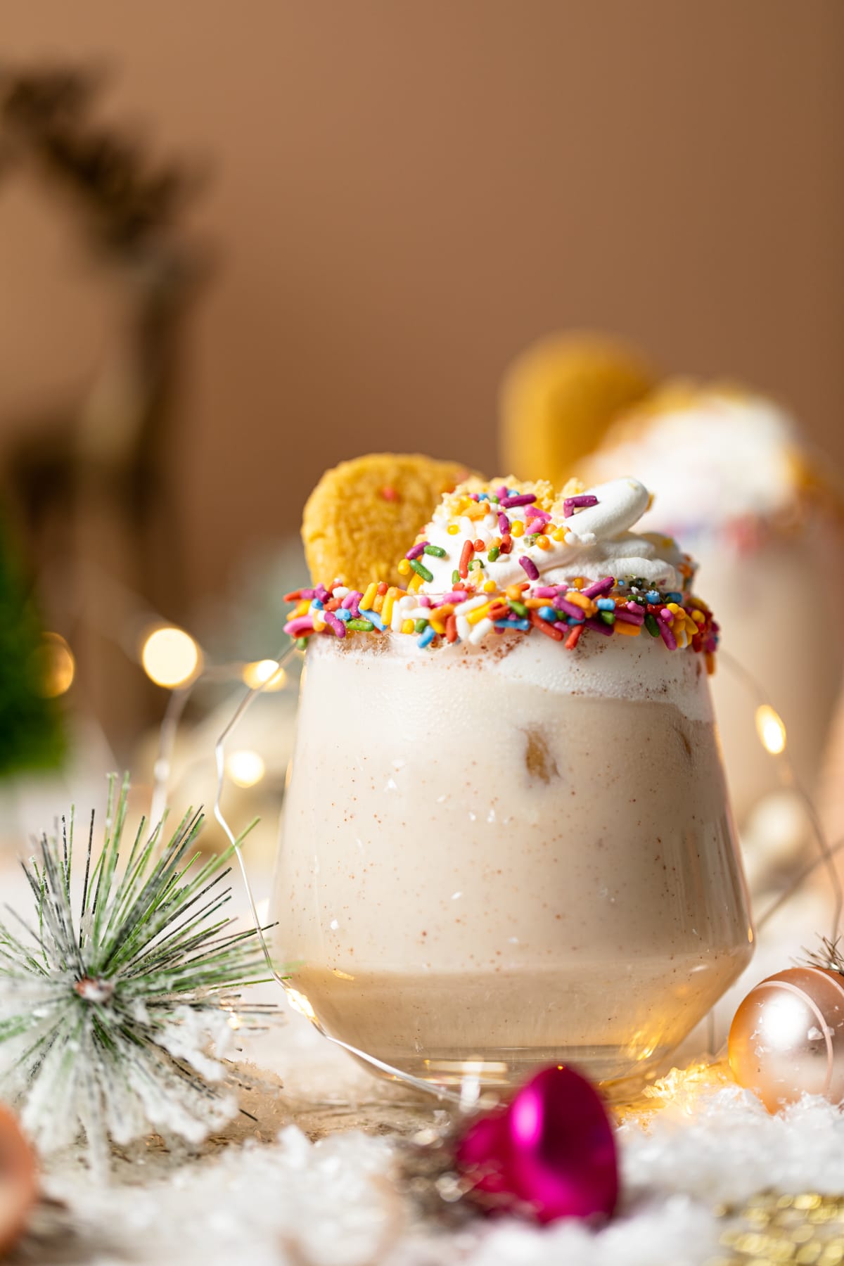 Drink topped with whipped cream, sprinkles, and a sugar cookie