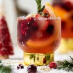 Holiday Mocktail stuffed with cranberries, strawberries, rosemary, and blood orange