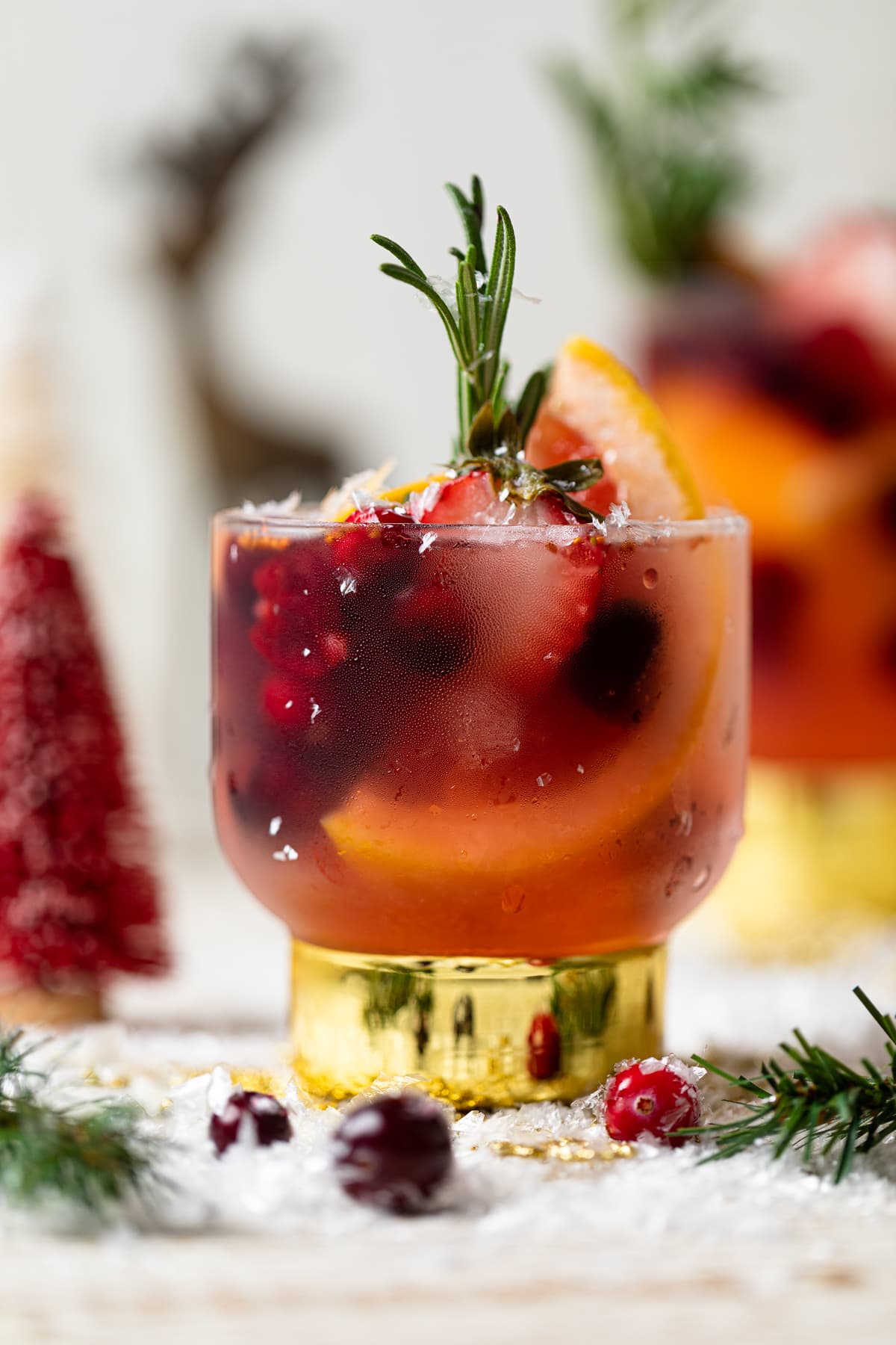 Holiday Mocktail stuffed with cranberries, strawberries, rosemary, and blood orange