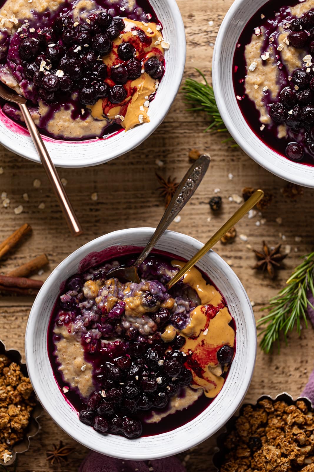 Overhead shot of bowls of Maple Blueberry Oatmeal Porridge with spoons