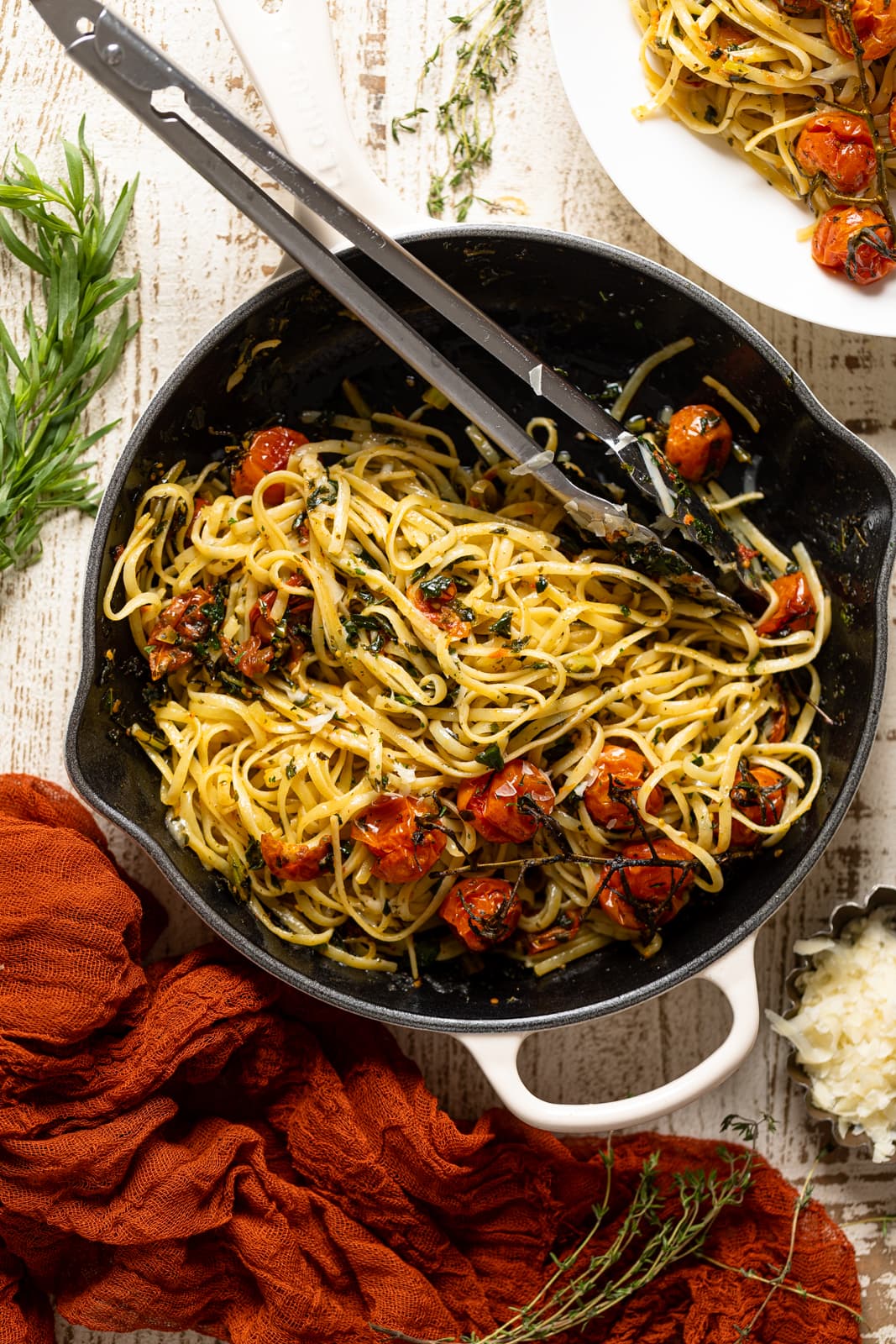 Tongs in a skillet of Bruschetta Pasta with Parmesan