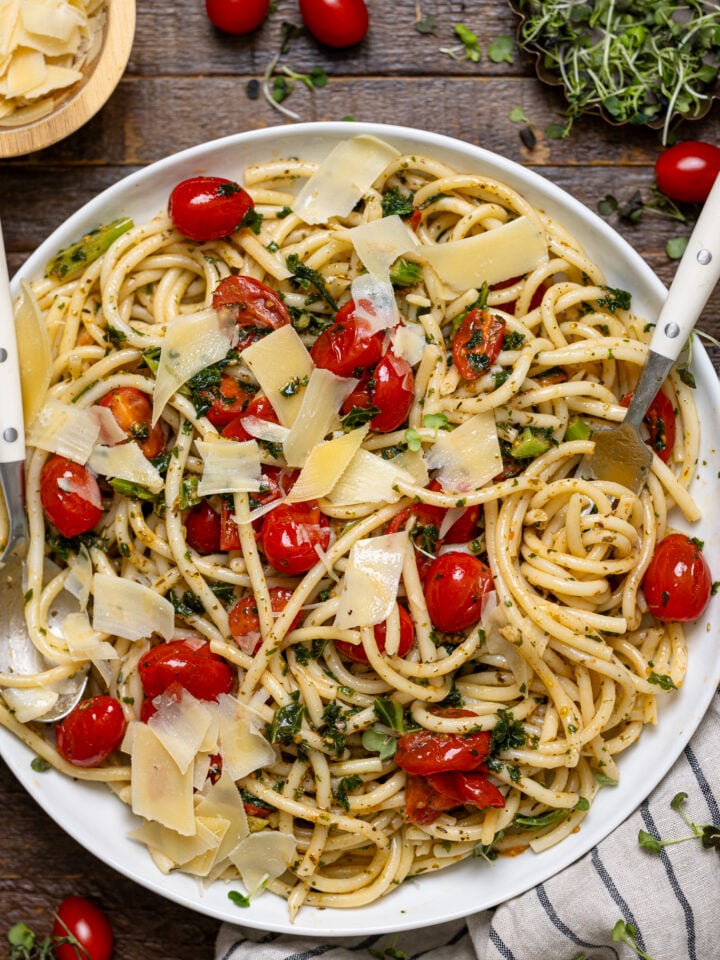 Easy Bruschetta Pasta with Parmesan in a serving platter with. utensils with garnish.