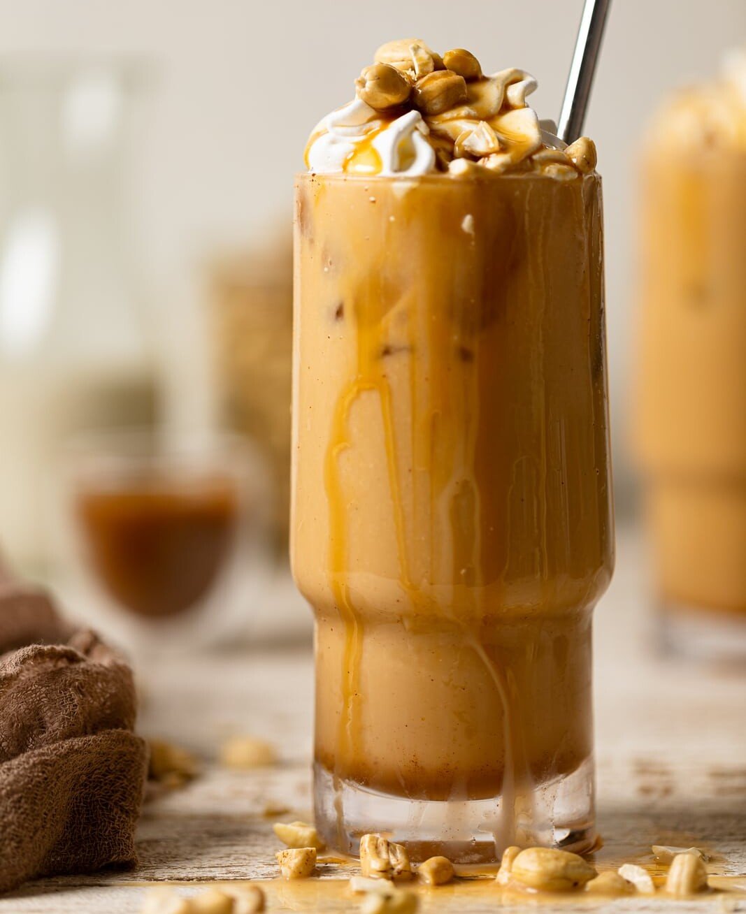 Salted Caramel Cashew Latte in a tall glass with caramel dripping down the side