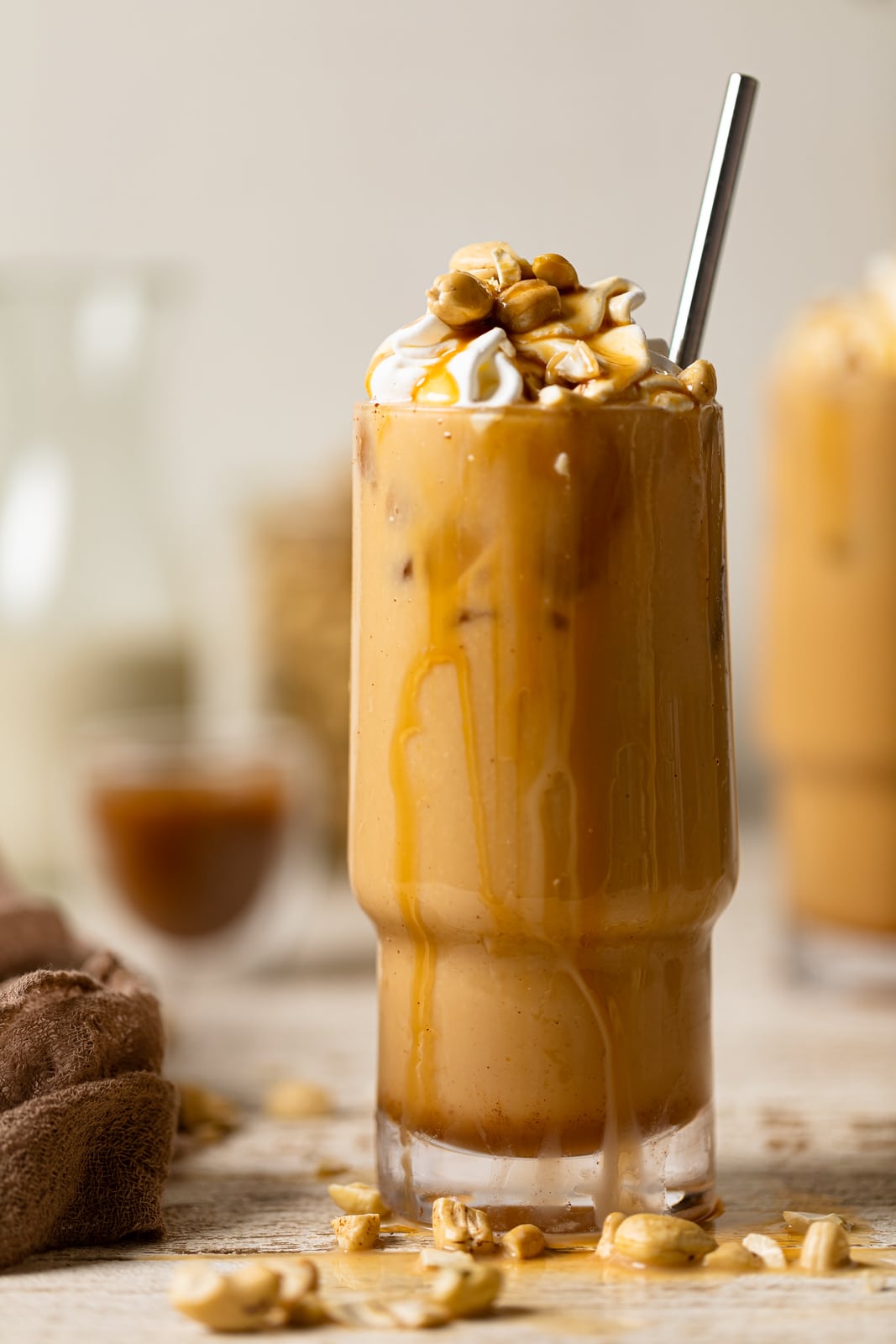 Salted Caramel Cashew Latte in a tall glass with caramel dripping down the side