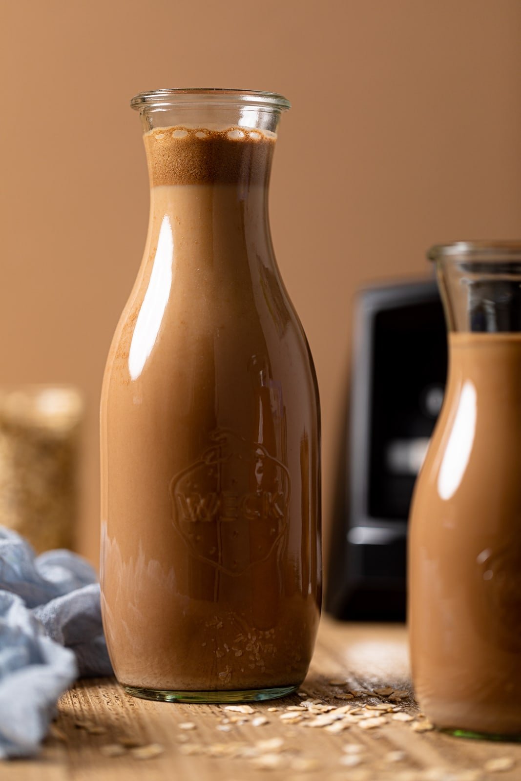 Two glass carafes of Chocolate Oat Milk