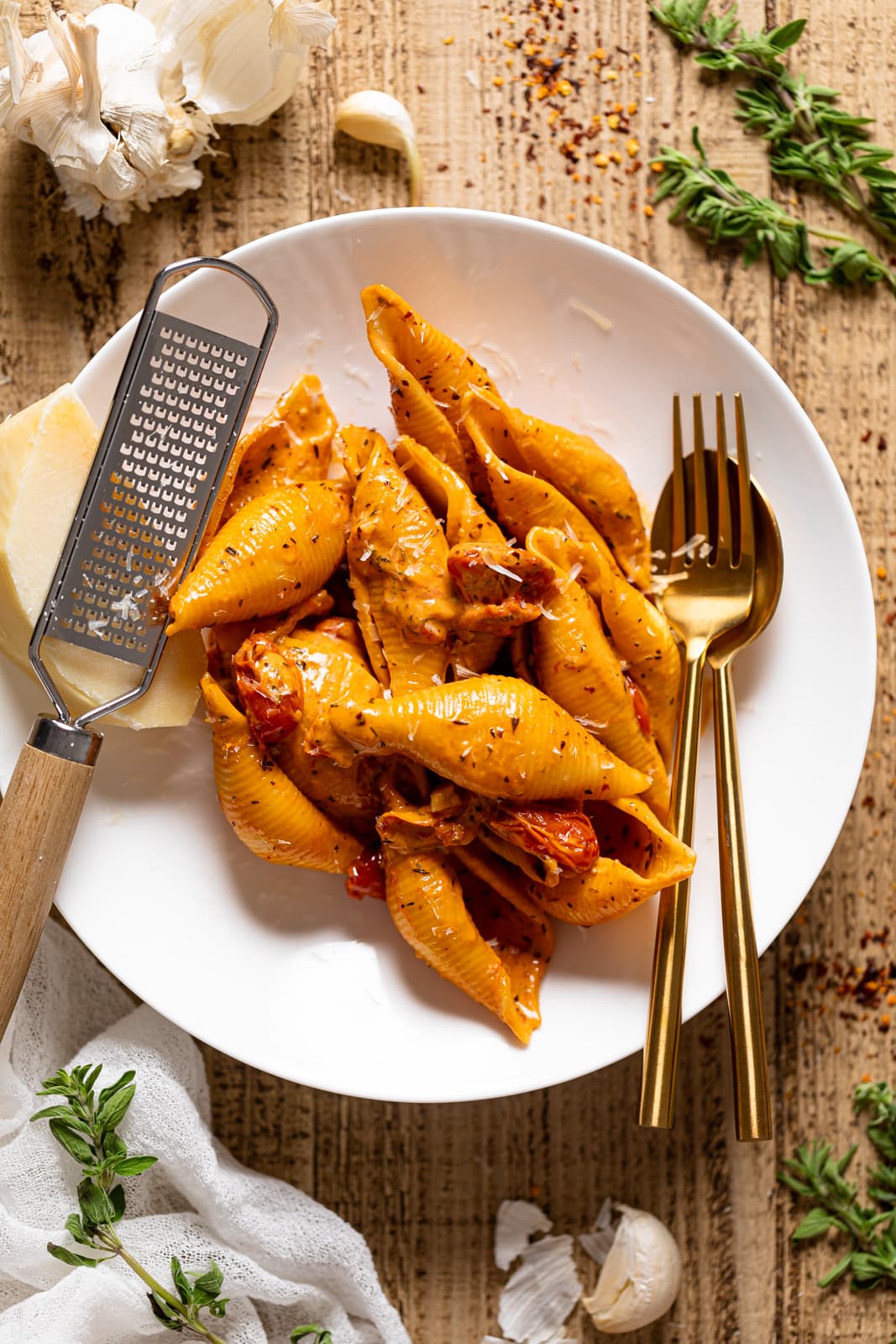 Plate of with silverware, a micro-grater, and Parmasean cheese