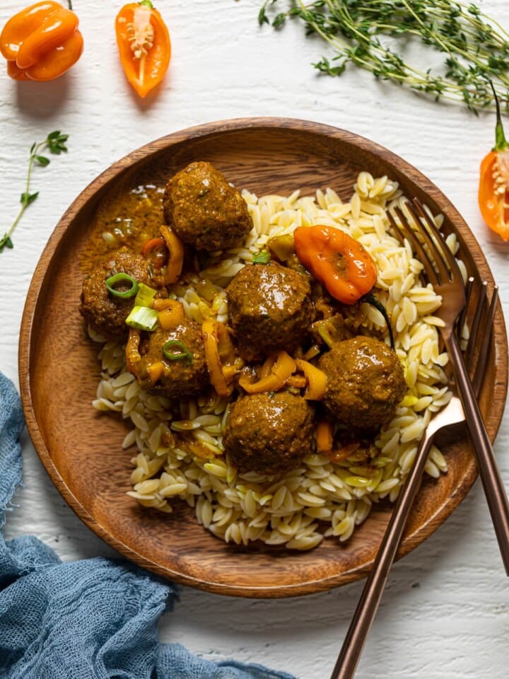 Wooden plate of Spicy Curry Vegan Meatballs with Orzo