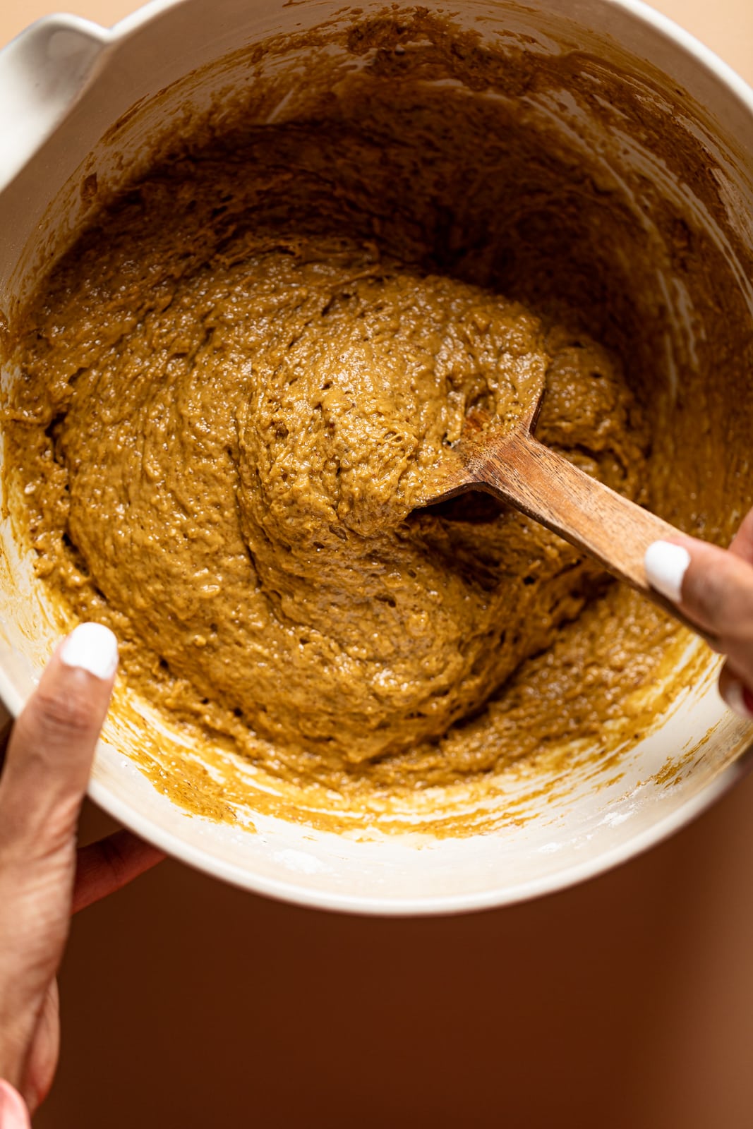 Wooden spoon stirring a bowl of Chai Ginger Bread dough