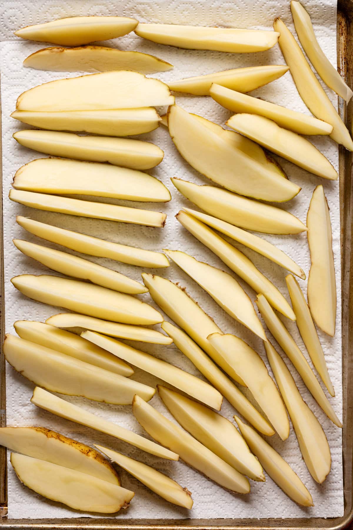 Cut potatoes on a baking sheet with paper towel, dried and laid side by side. 