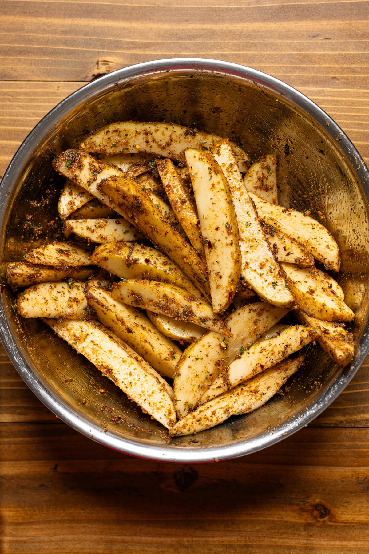 Wedges in a silver bowl with seasoning. 