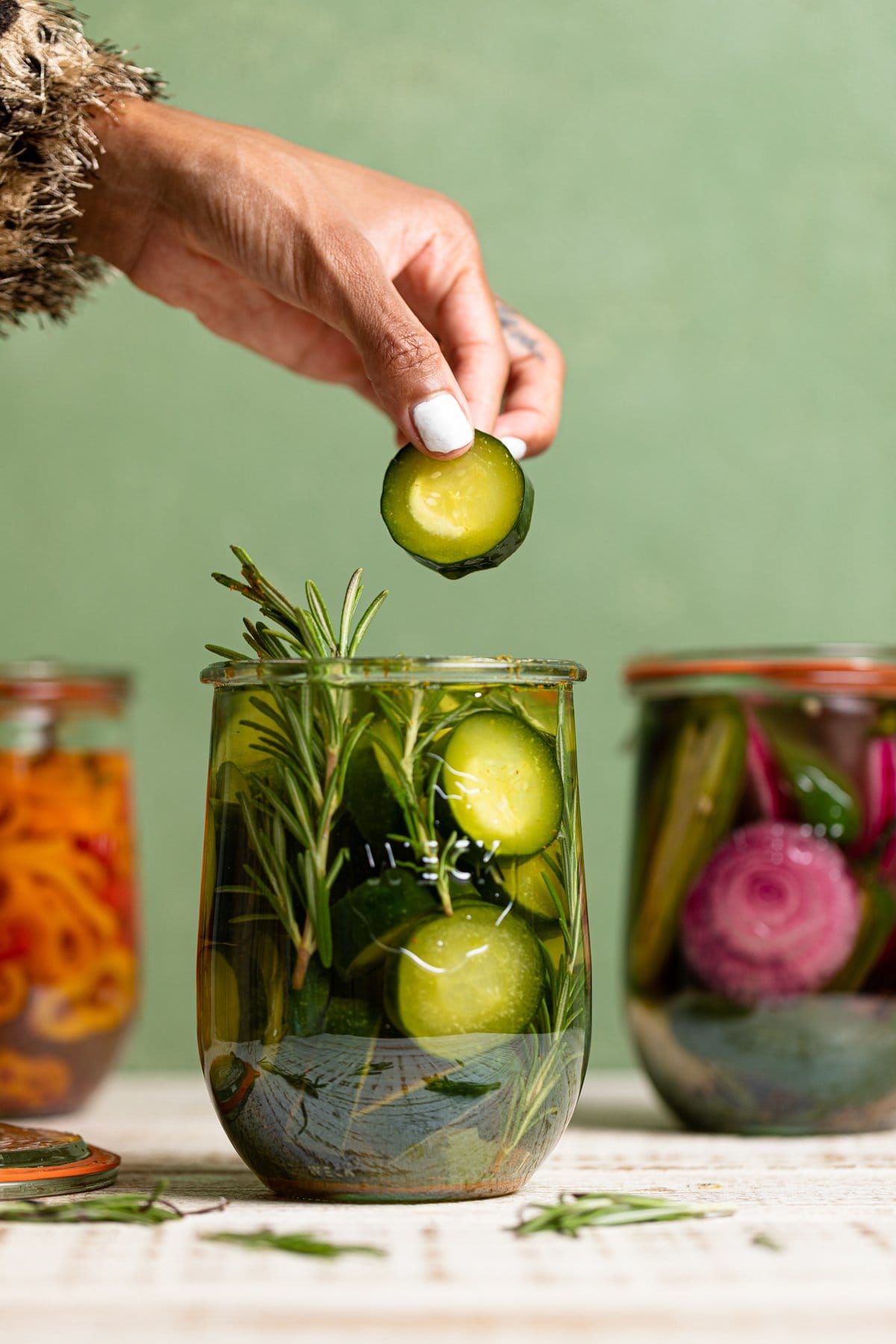 Hand grabbing a quick pickled vegetable our of a jar