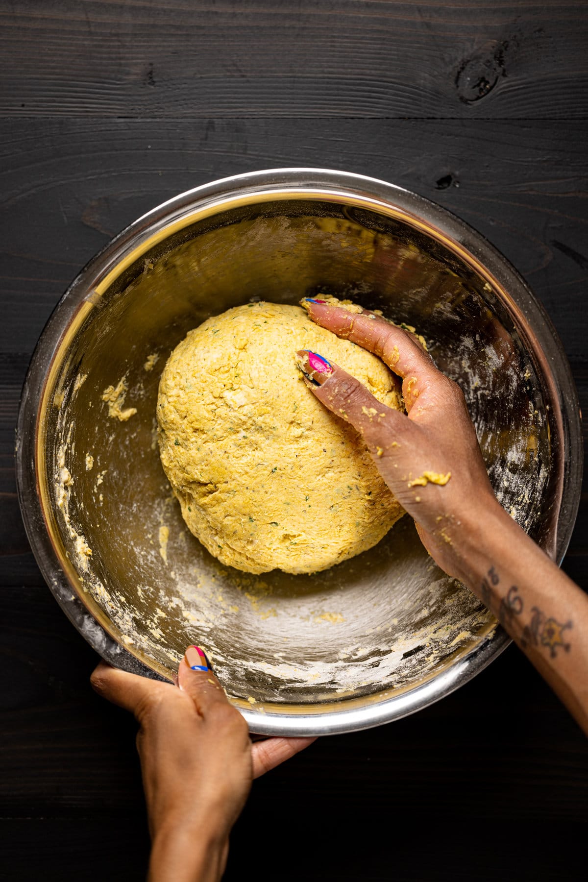 Hand on a ball of dough in a bowl