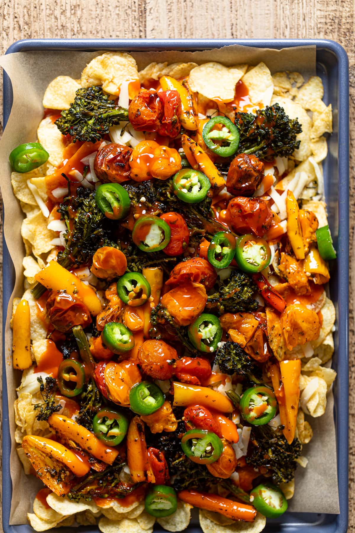 Kettle chips, red sauce, shredded cheese, and roasted vegetables topped jalapeno slices