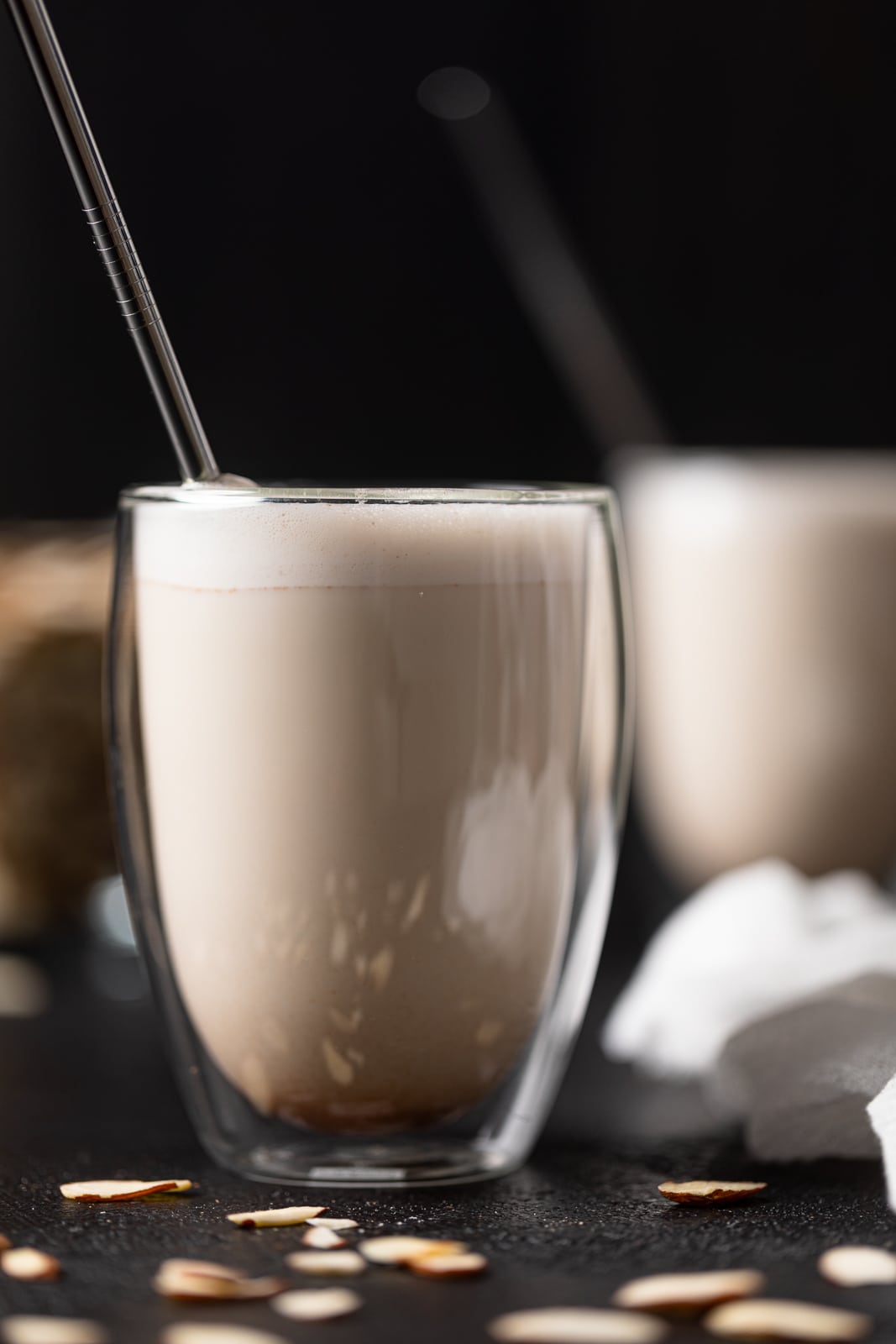 Closeup of a glass of almond milk with a straw