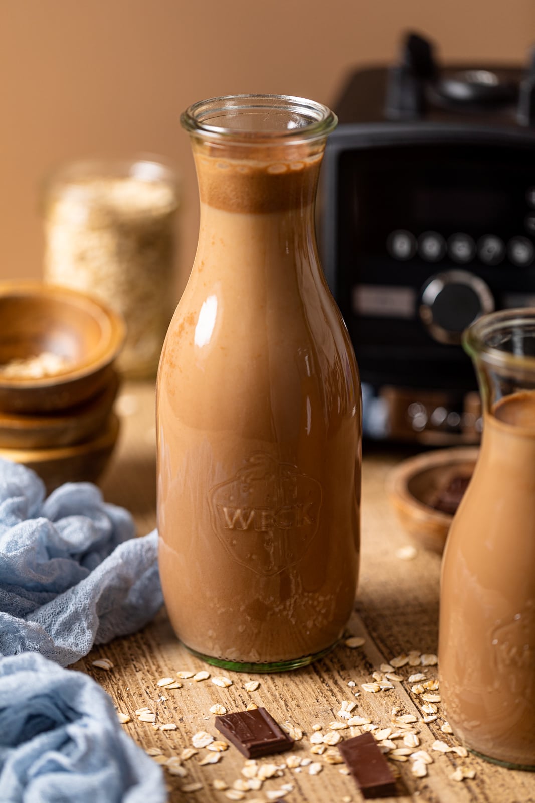 Two glass carafes of Chocolate Oat Milk