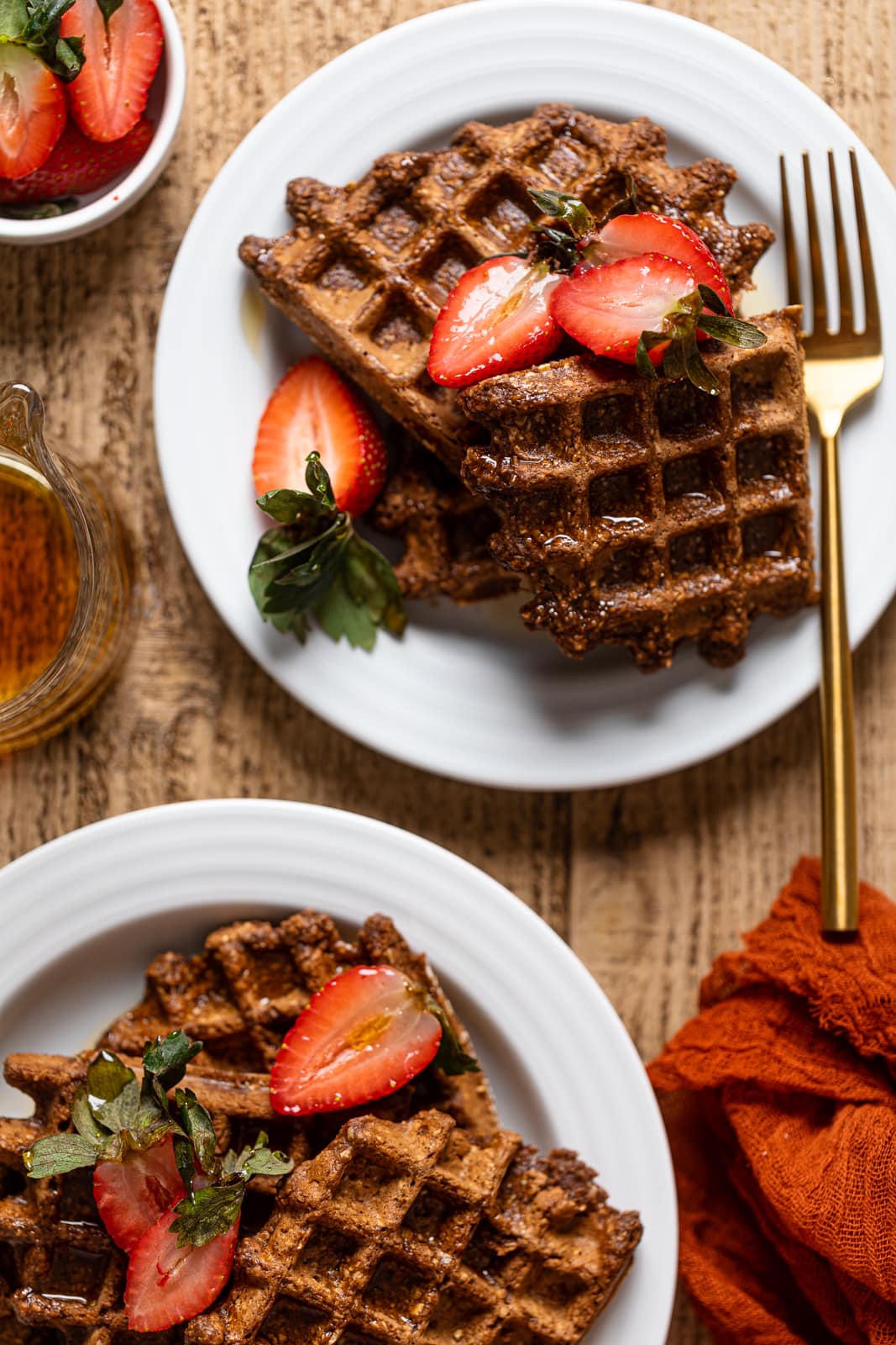 Two plates of Flourless Espresso Chocolate Waffles with Strawberries