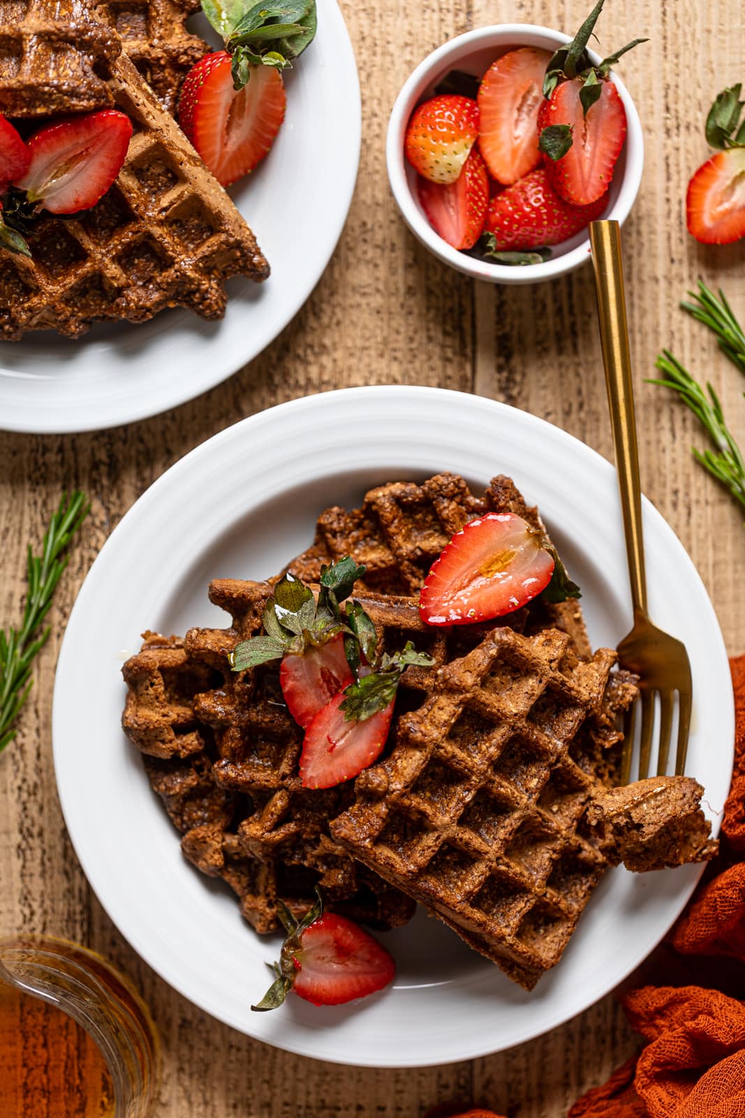 Two plates of Flourless Espresso Chocolate Waffles with Strawberries