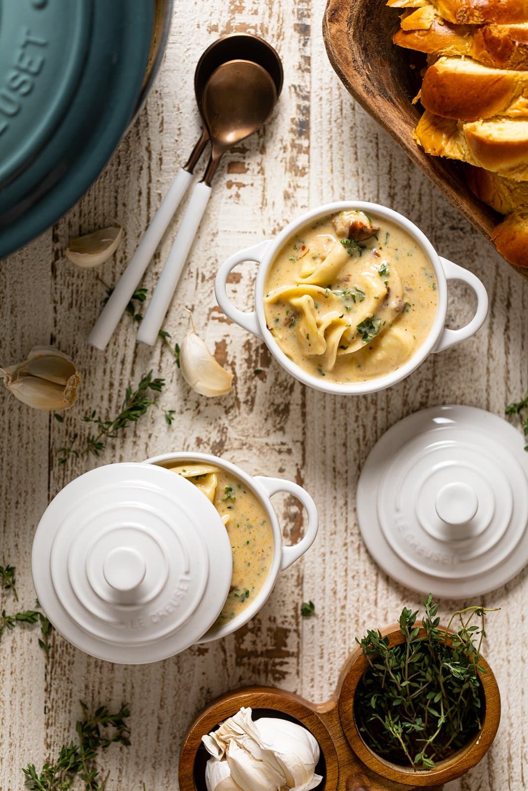 Creamy Roasted Garlic Tortellini Soup in two small Le Creuset handled bowls