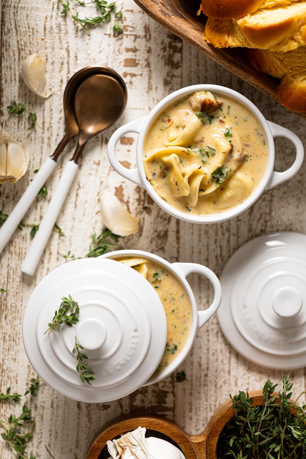 Creamy Roasted Garlic Tortellini Soup in two small Le Creuset handled bowls