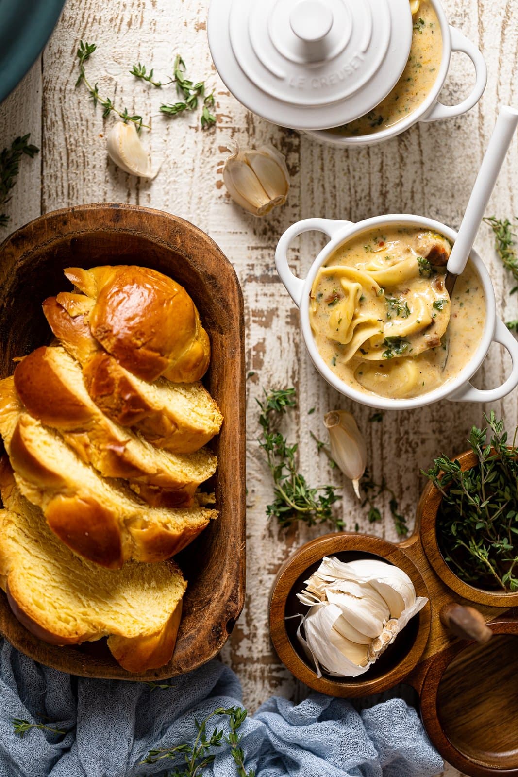 A wooden bowl of sliced bread, with other ingredients in wooden bowls