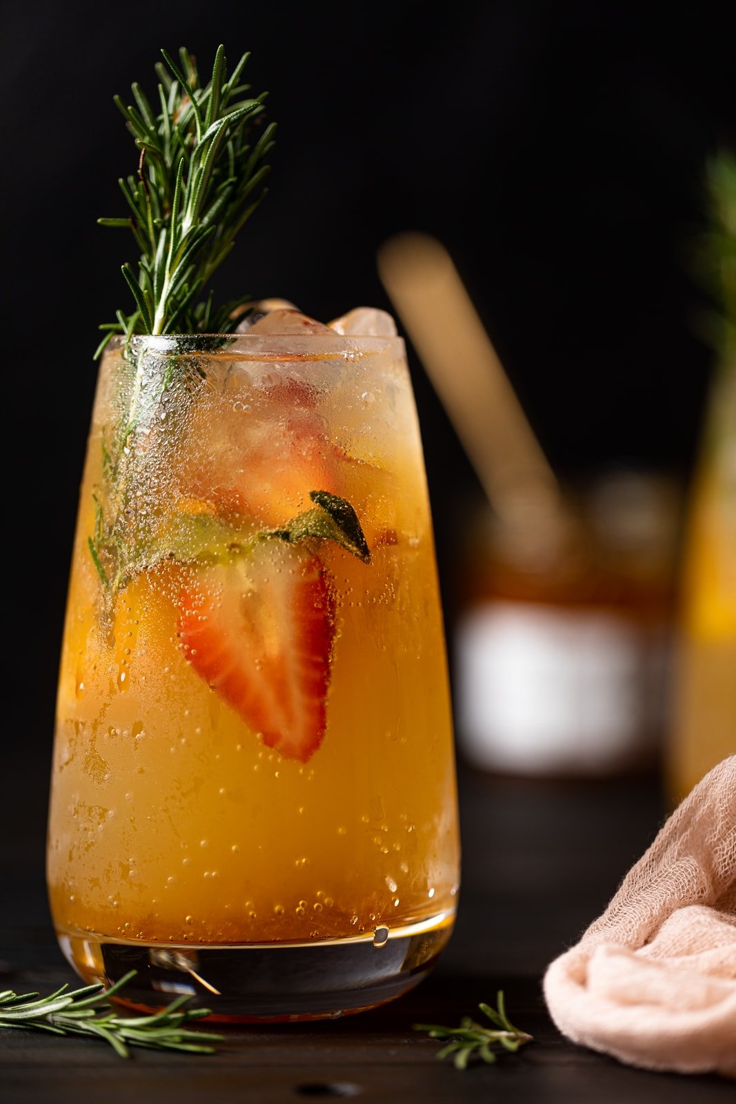 Peachy Ginger Beer Mocktail with halved strawberries and rosemary sprigs