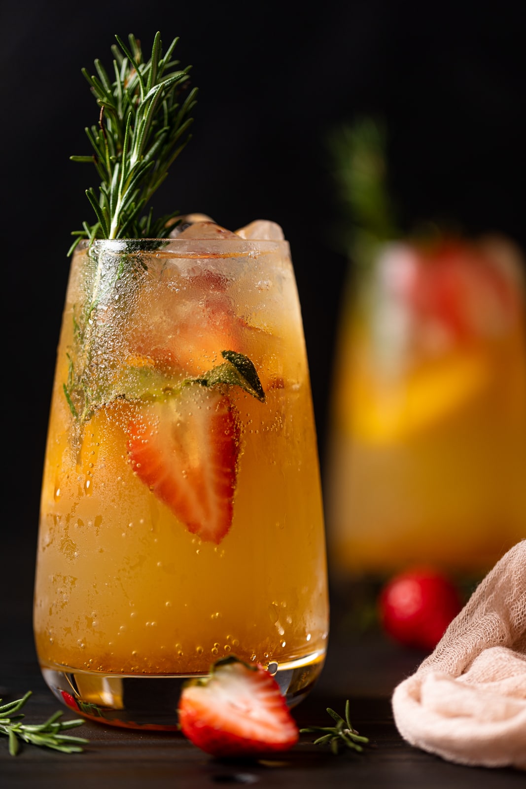 Peachy Ginger Beer Mocktail with halved strawberries and rosemary sprigs