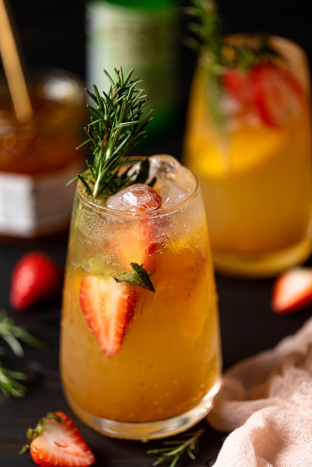 Peachy Ginger Beer Mocktail with halved strawberries, rosemary sprigs, and ice